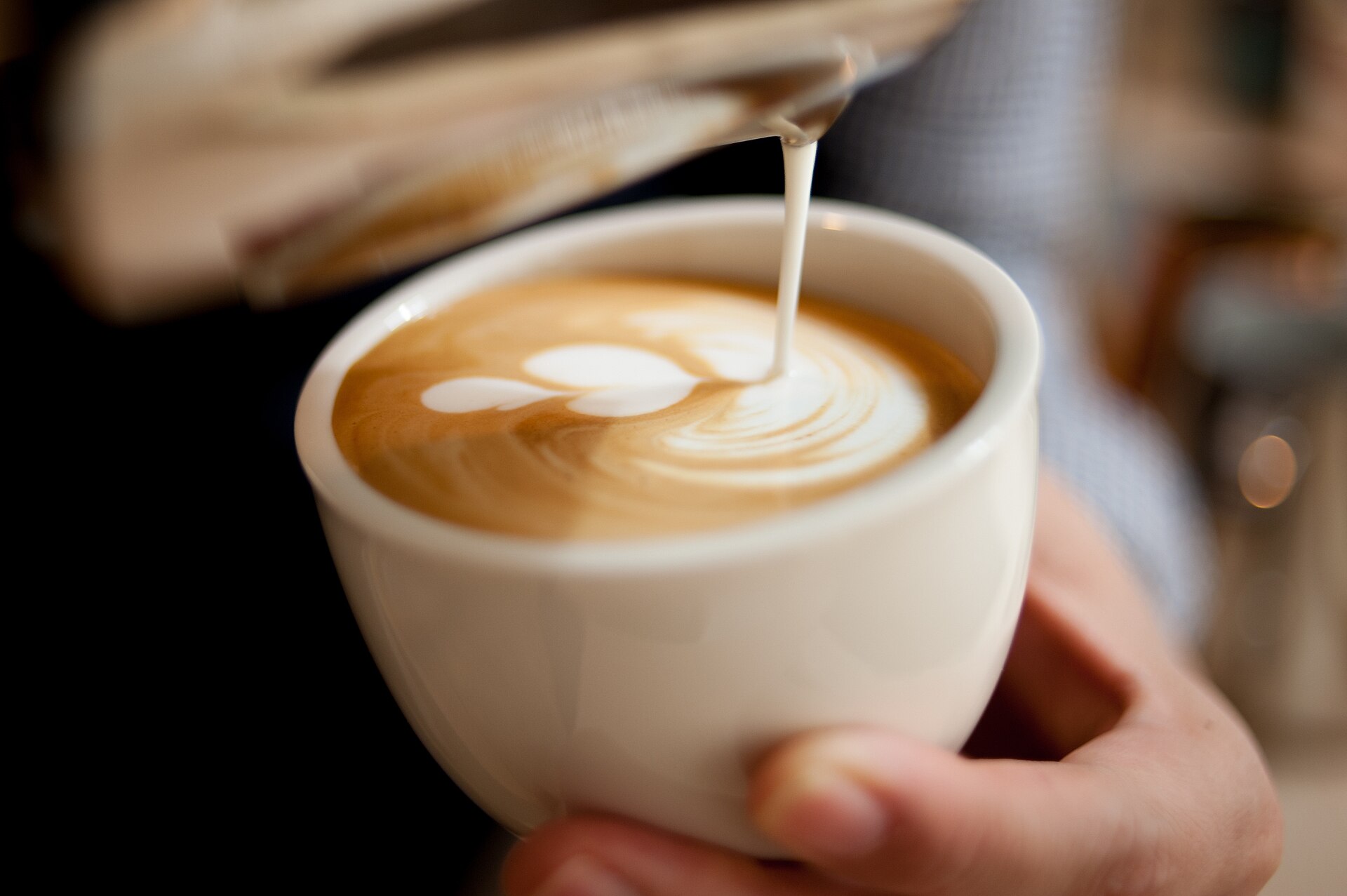 Sipanje mleka u šolju kafe sa latte art šarom